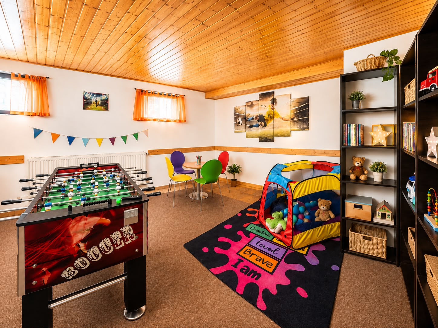 Das Spielzimmer der Villa Johannes mit Kickertisch, Spielzelt und Regalen voller Spielsachen