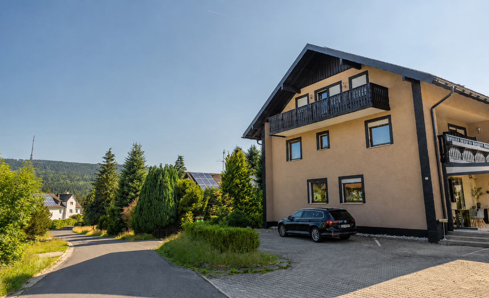 Die Zufahrt zur Villa Johannes mit der Fassade und den bewaldeten Höhen daneben